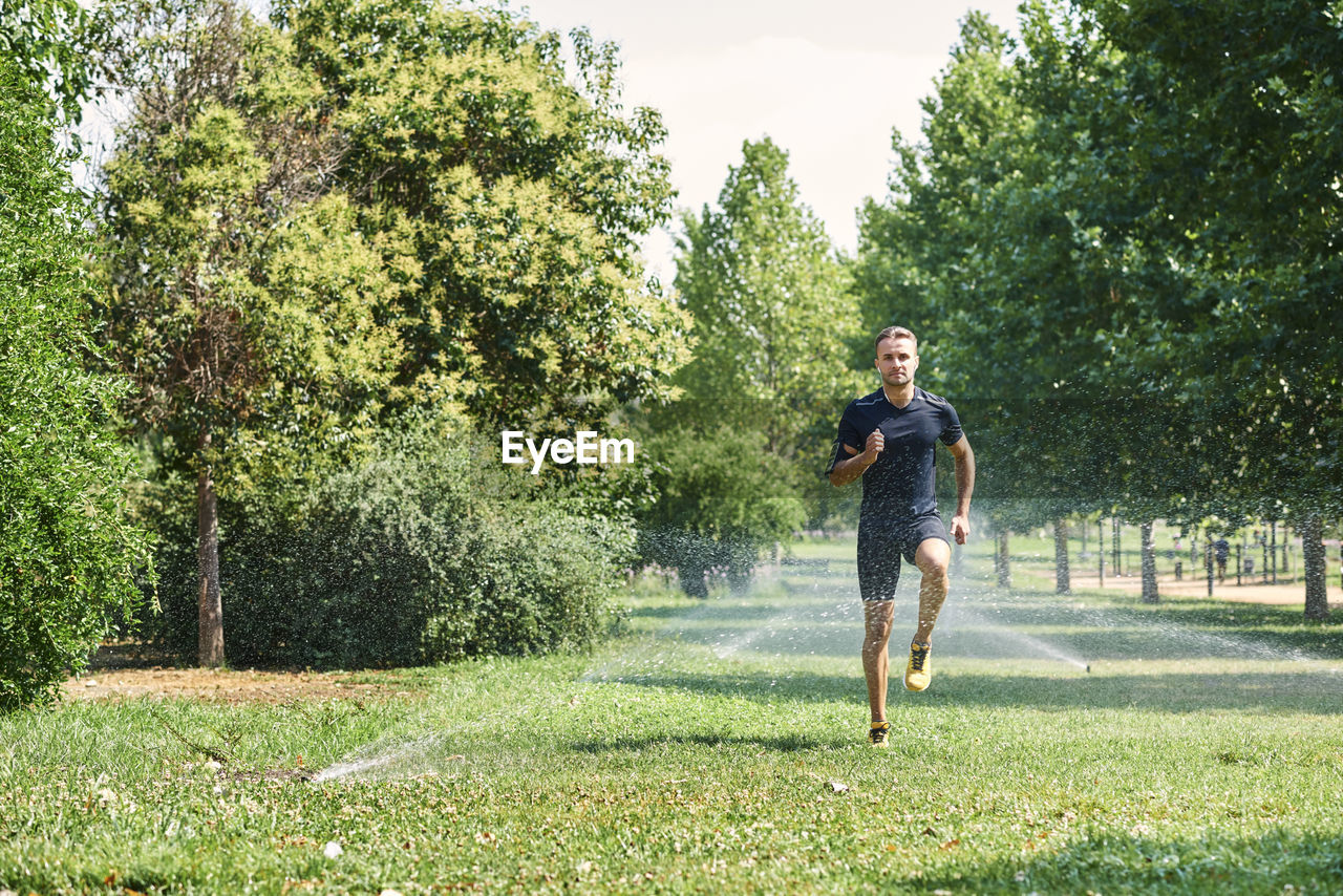 Young man training in a park, he is jogging.