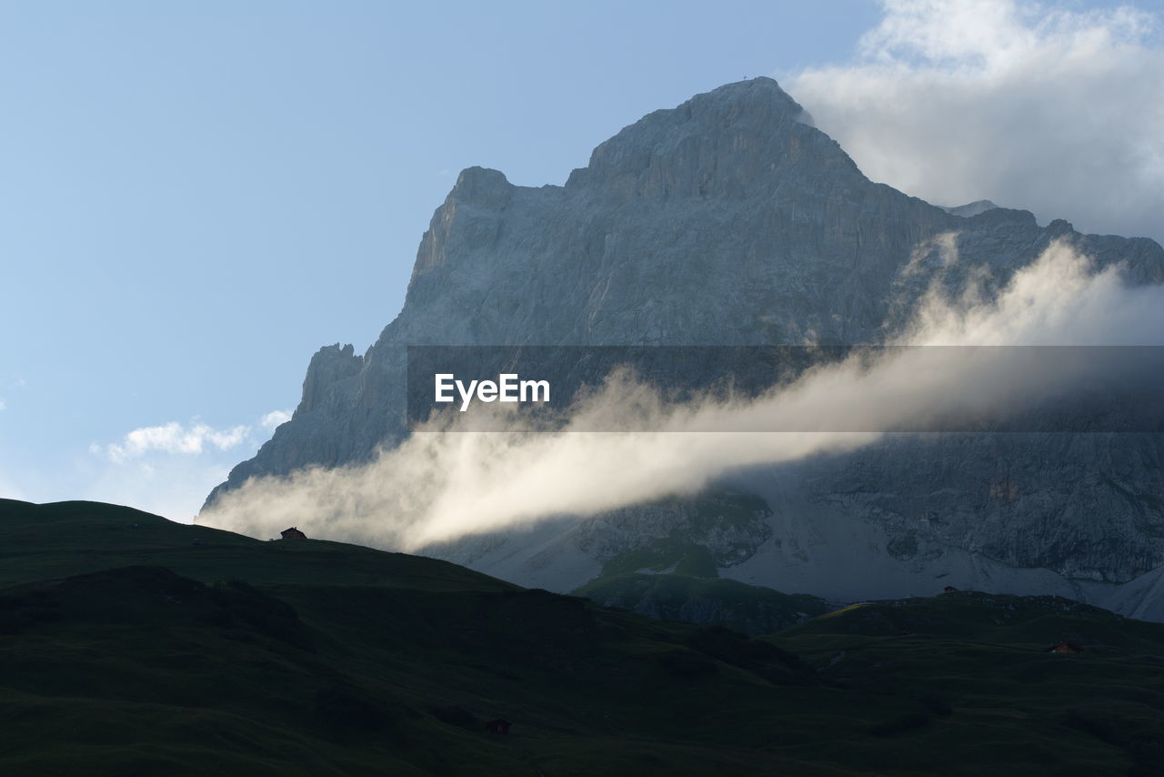 Last sunray on cloud next to swiss mountain.