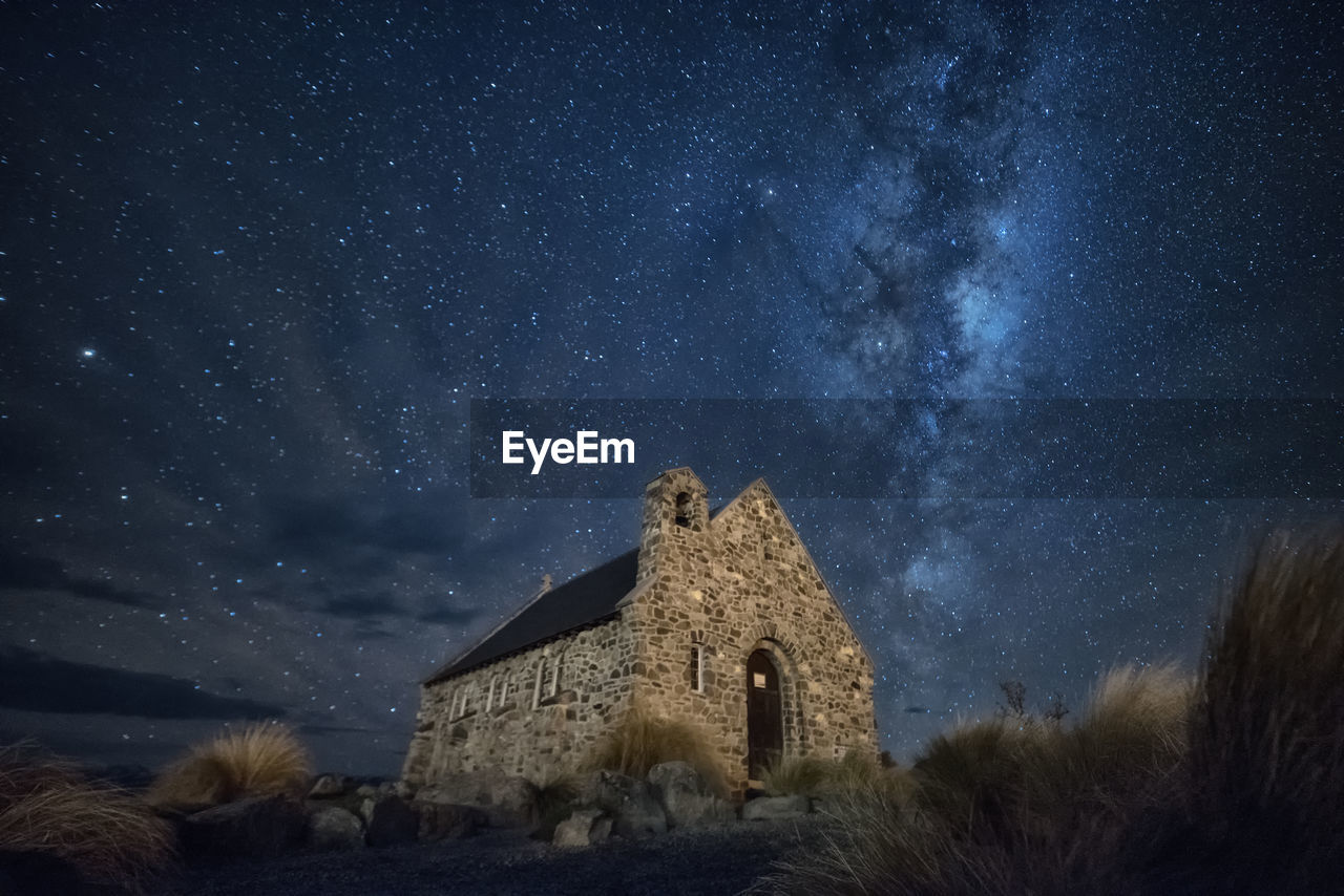 Low angle view of church against star field
