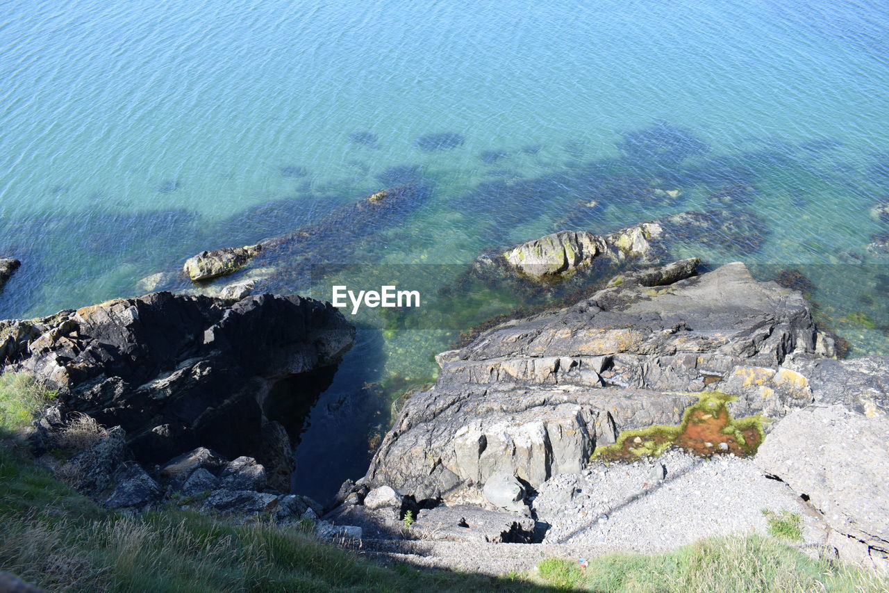 HIGH ANGLE VIEW OF ROCKS ON SHORE AT BEACH