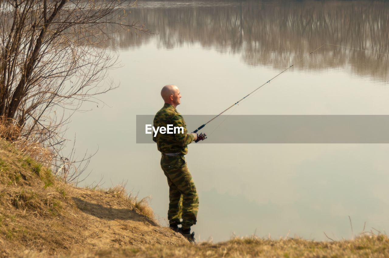 MAN FISHING AT LAKE