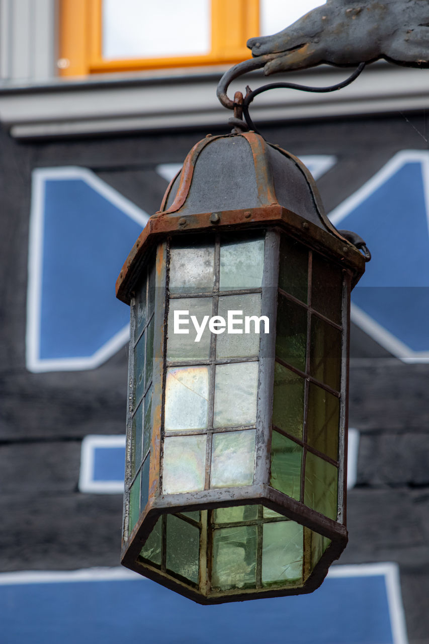 LOW ANGLE VIEW OF LANTERN HANGING OUTSIDE HOUSE