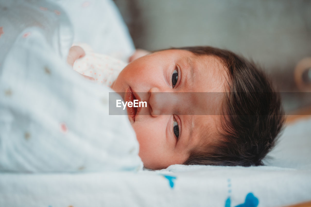 Newborn baby girl in hospital eyes wide open