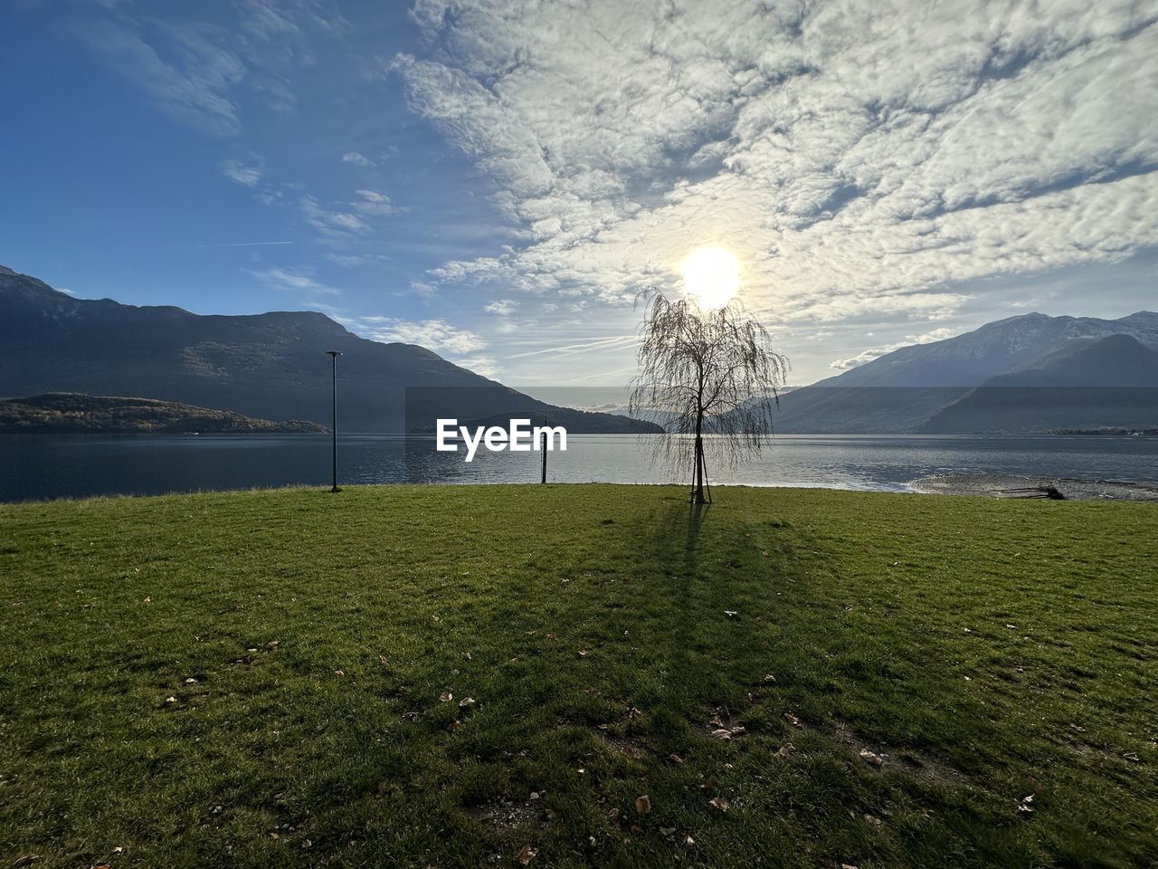 horizon, sky, nature, mountain, water, morning, scenics - nature, sunlight, beauty in nature, grass, plant, environment, reflection, land, lake, landscape, tranquility, tranquil scene, cloud, no people, mountain range, tree, outdoors, body of water, day, travel destinations, beach, non-urban scene, green, idyllic, blue, dusk, travel, shore