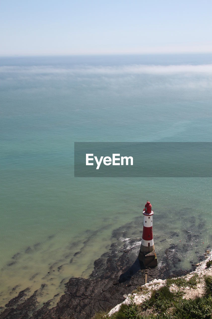 MAN LOOKING AT SEA AGAINST SKY