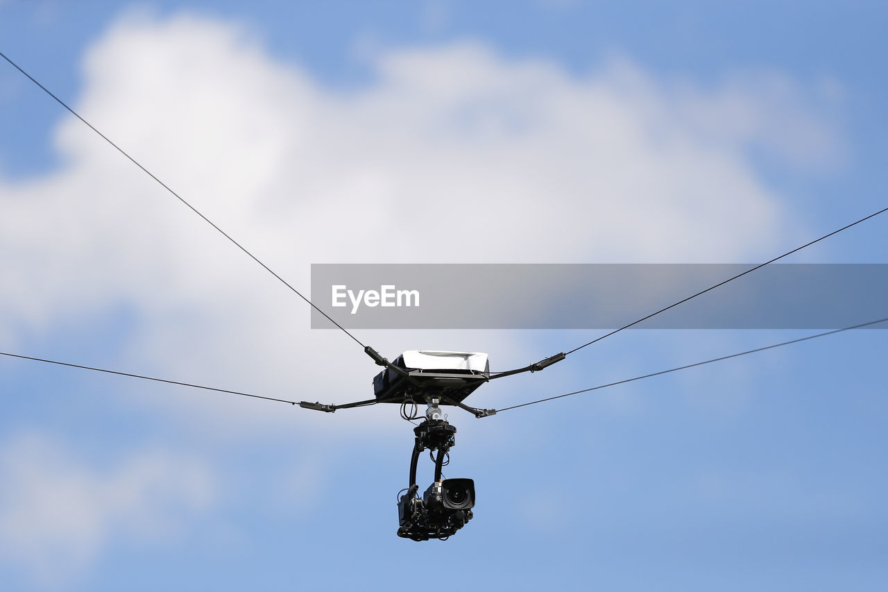 Low angle view of camera attached on rope against sky