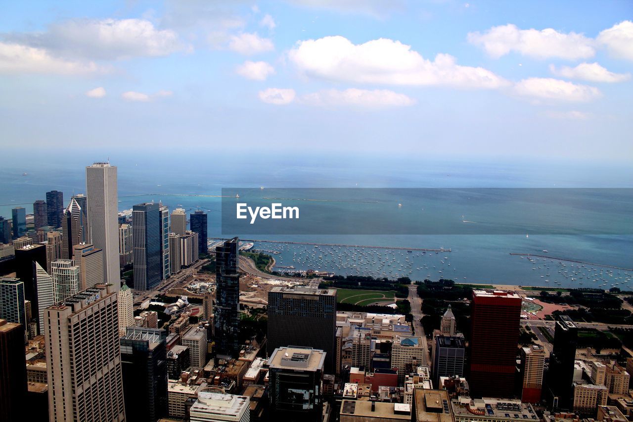 High angle view of buildings by sea against sky