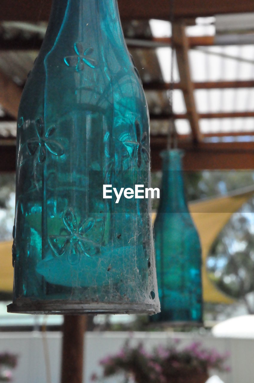 Low angle view of glass bottles hanging from roof