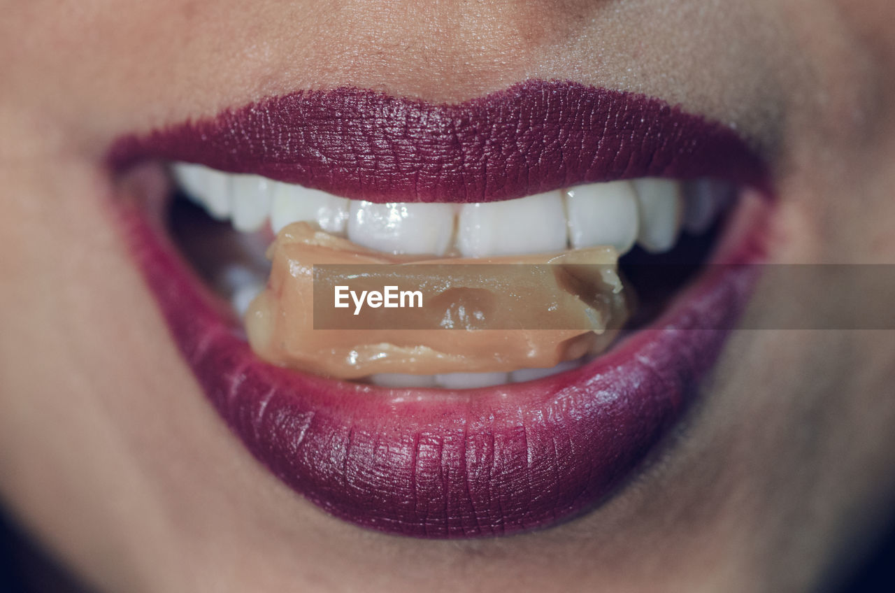 Close-up of woman with candy in mouth