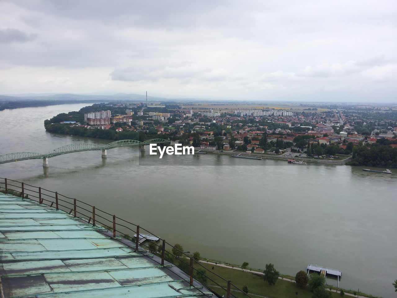 Cityscape with bridge over river against sky