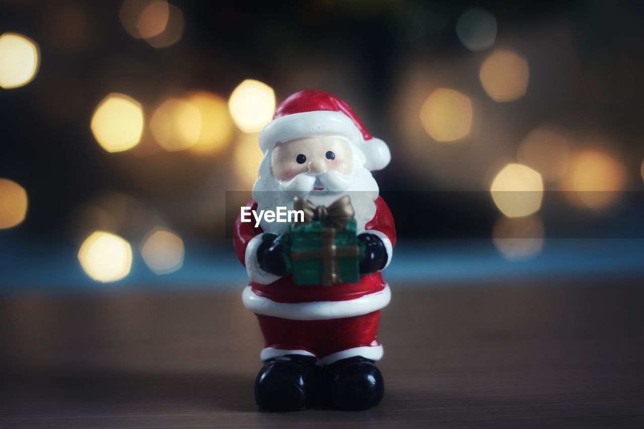 Santa figurine against illuminated lights