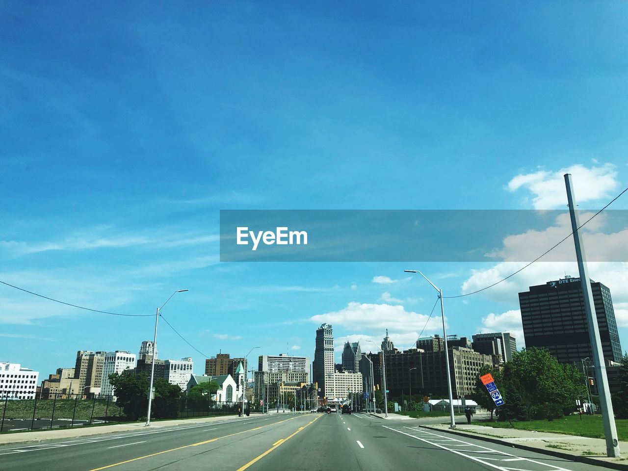 VIEW OF CITY STREET AGAINST BLUE SKY