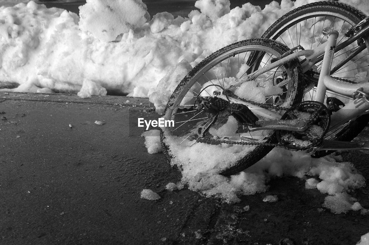 HIGH ANGLE VIEW OF ABANDONED BICYCLE ON ROAD