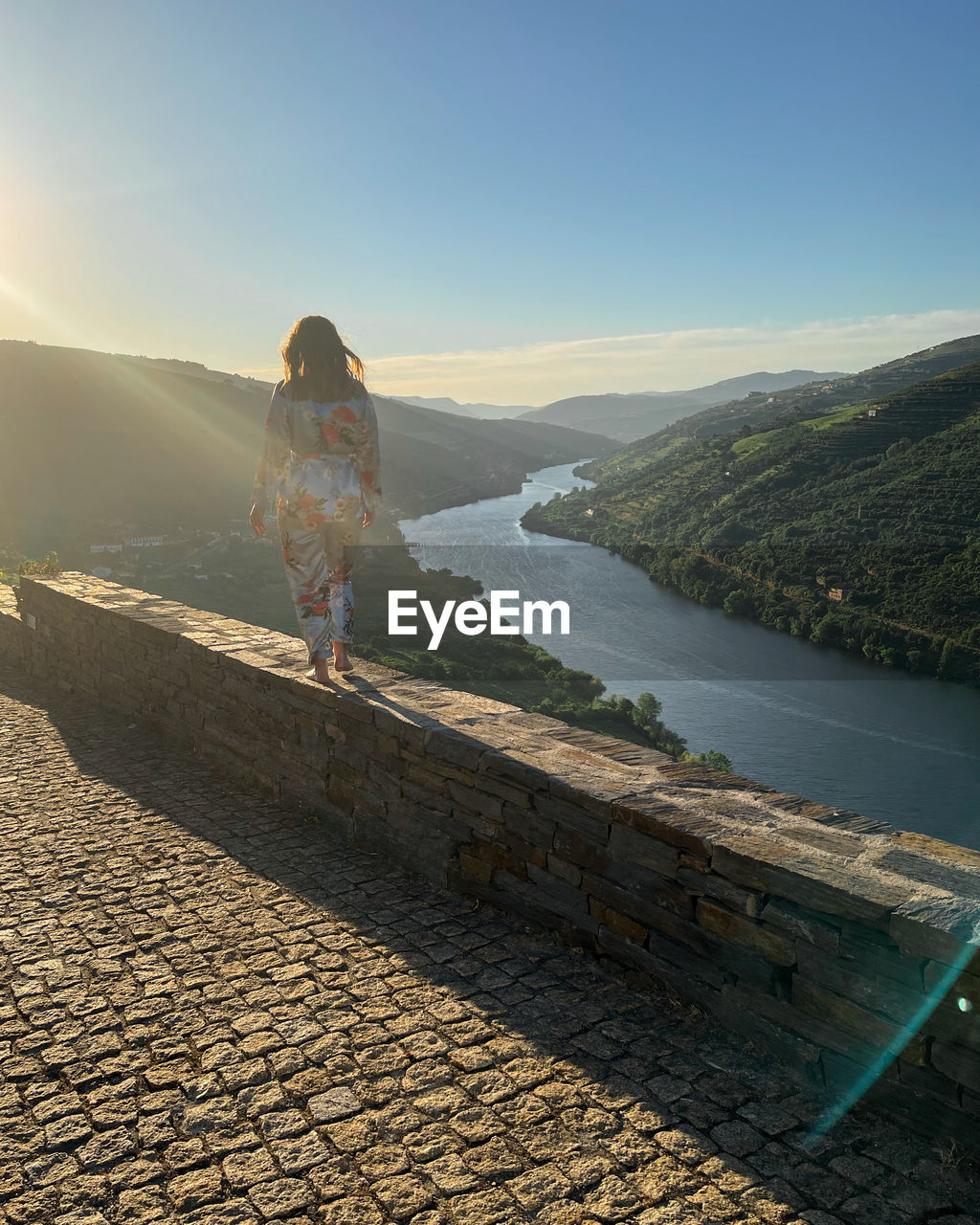 Rear view of woman standing on mountain against sky