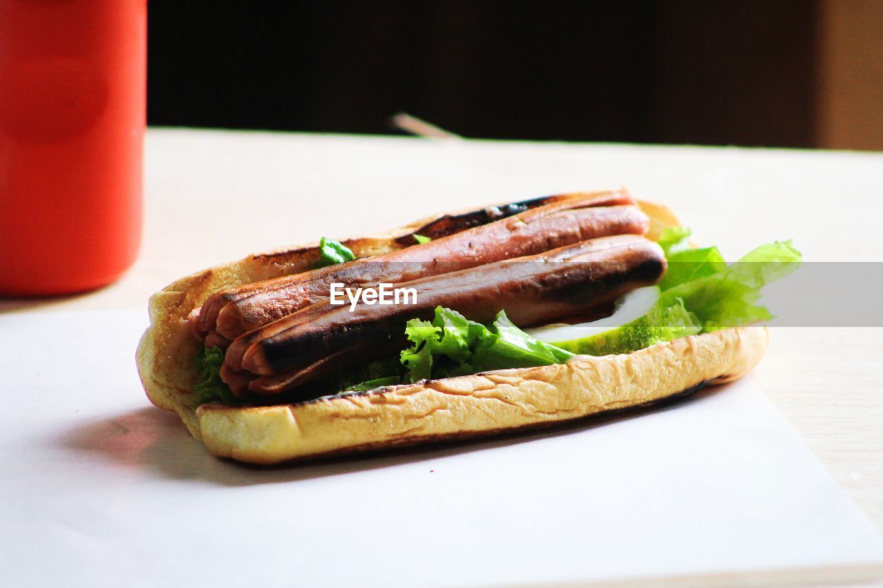 Photo of sausage on bread with vegetables as a meal