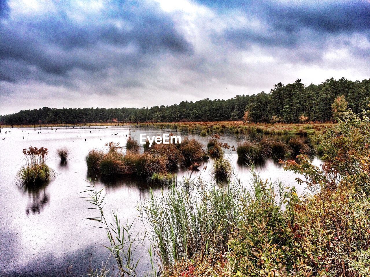 SCENIC VIEW OF LAKE AGAINST CLOUDY SKY