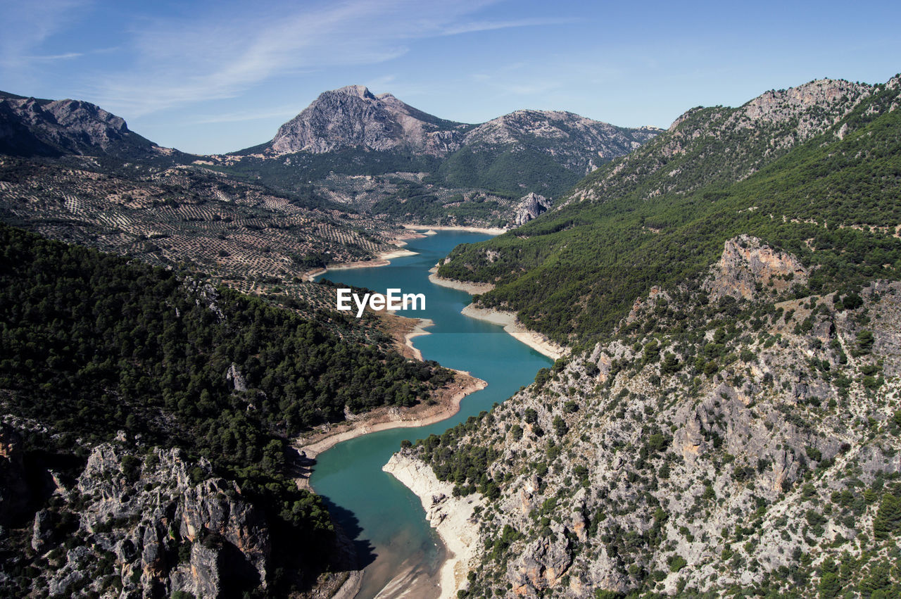 High angle view of river amidst mountains against sky