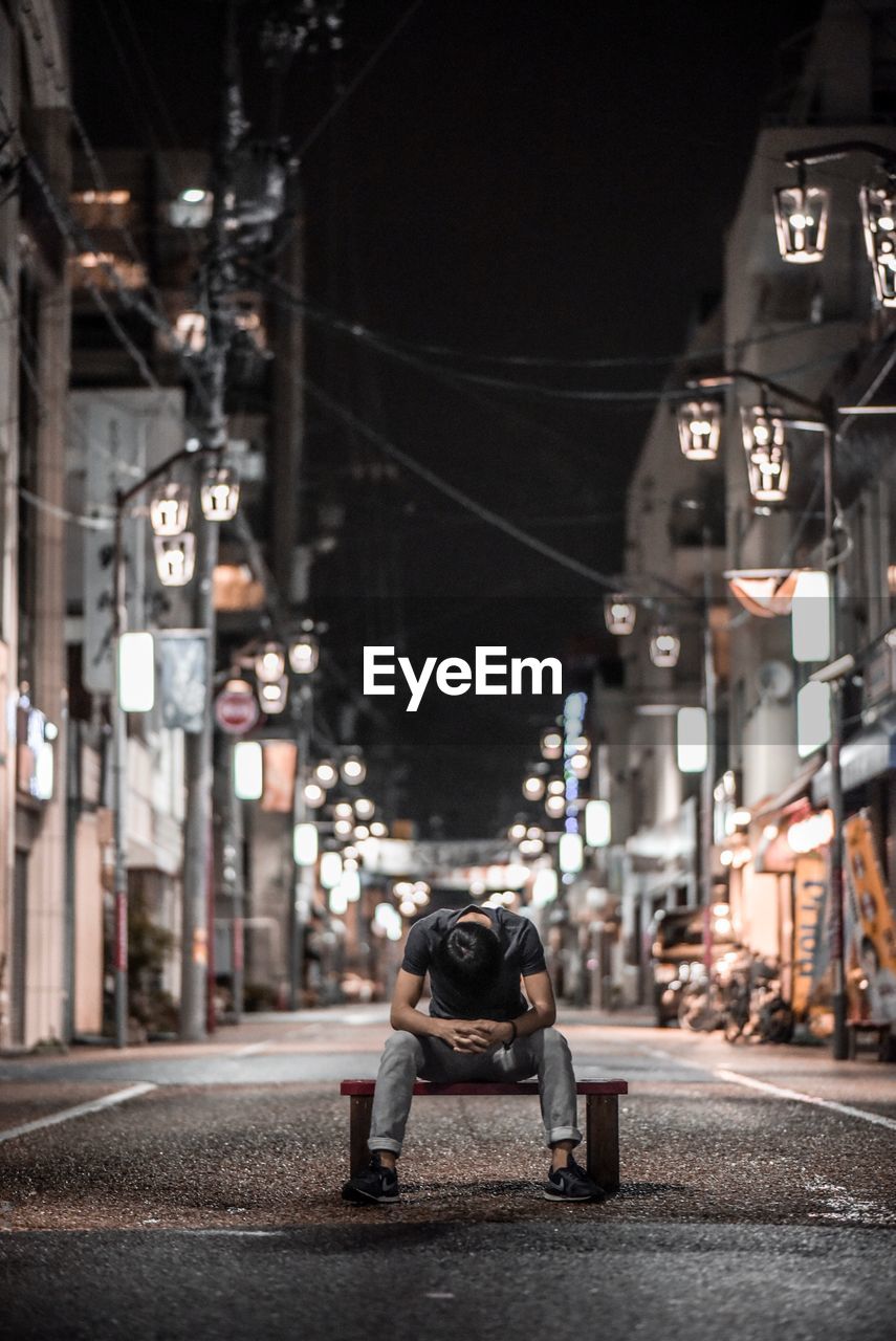 Man on illuminated street at night