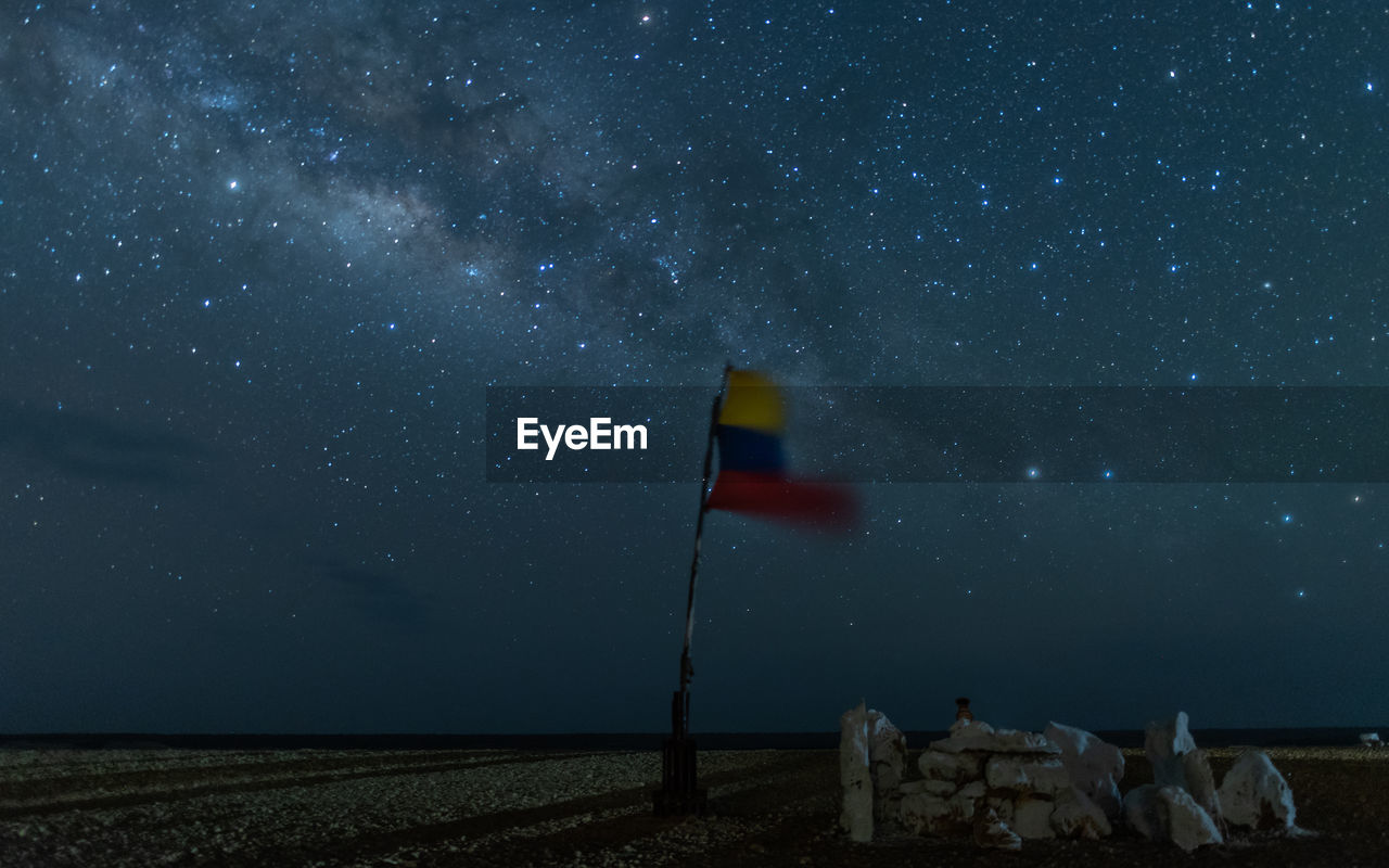 Scenic view of colombian flag on field against sky at night