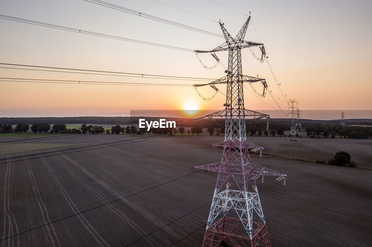Transmission power, power tower on an empty farm land at the sunset. aerial drone photograph.