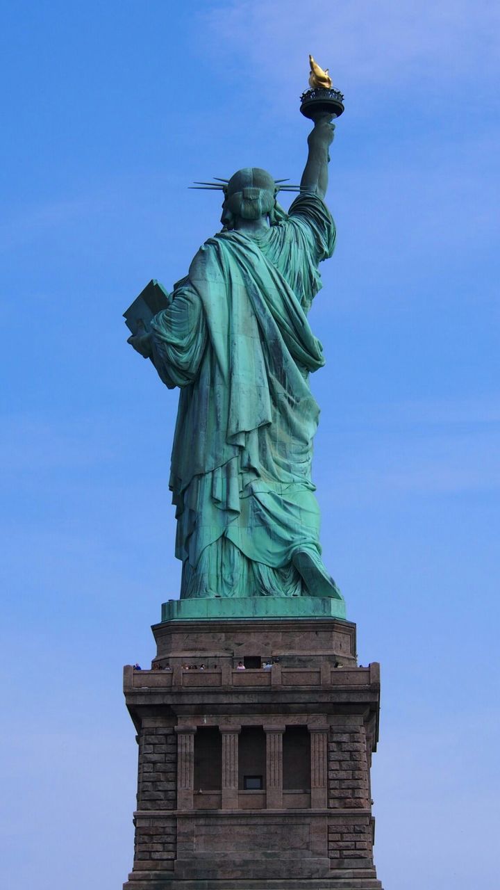 Low angle view of statue of liberty against blue sky