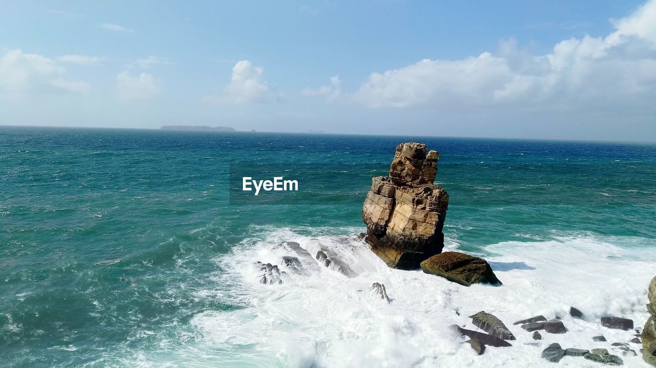 Rocks in sea against sky