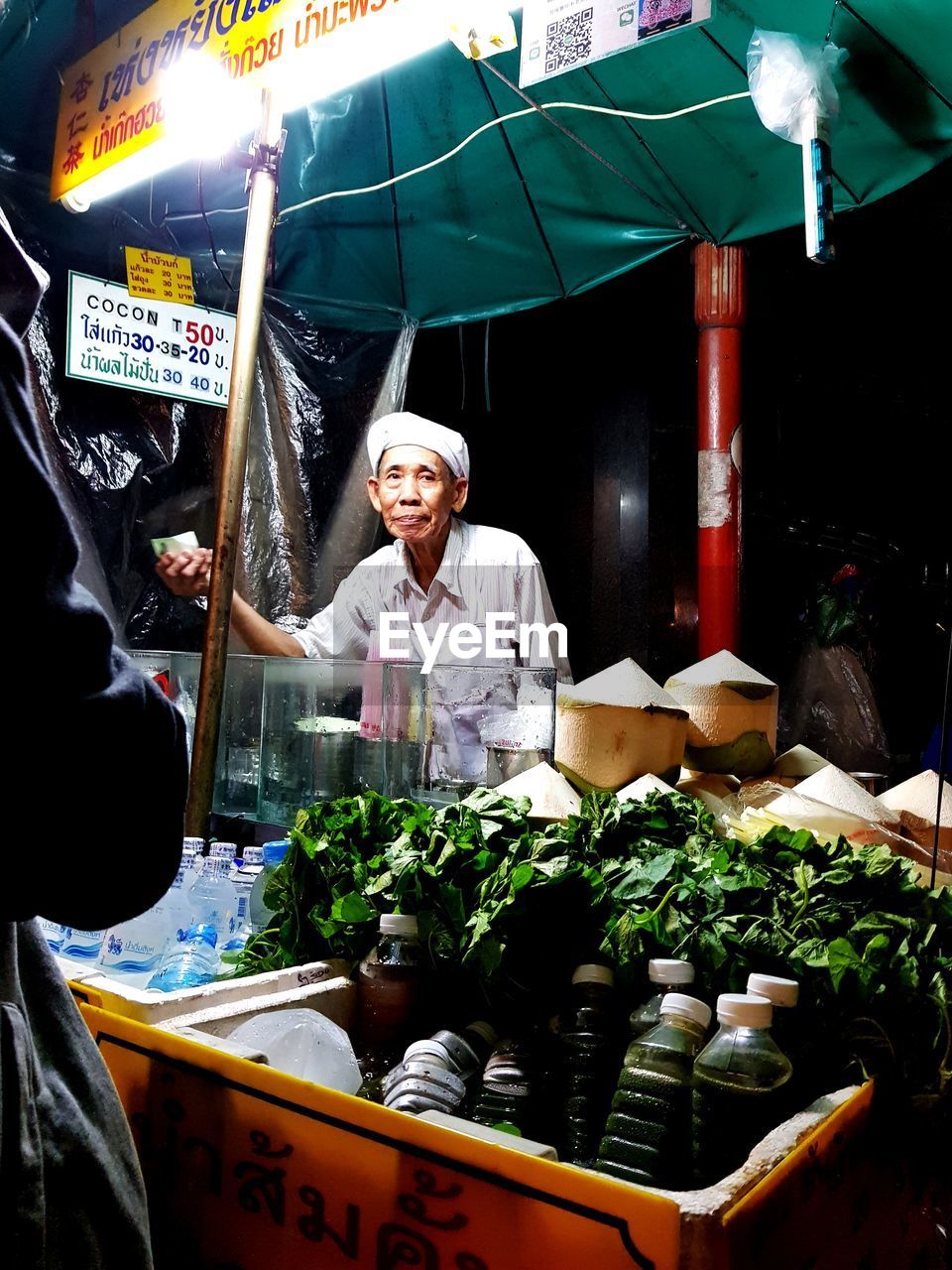 Senior market vendor looking away while standing at stall