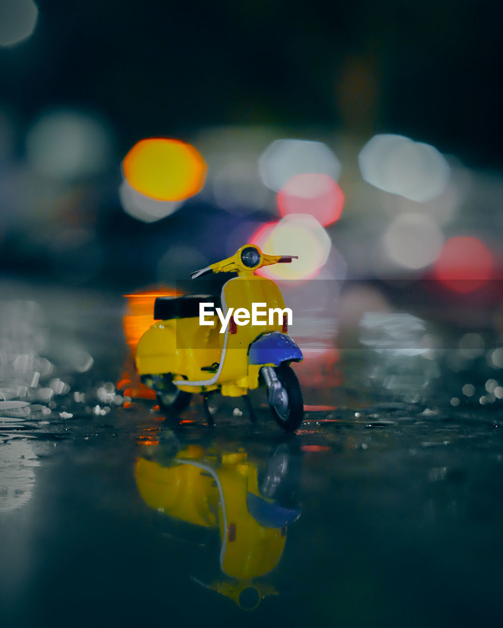 reflection, yellow, water, wet, macro photography, nature, outdoors, toy, blue, night, cartoon, transportation, childhood, selective focus, rain, one person, vehicle, person, swimming, city