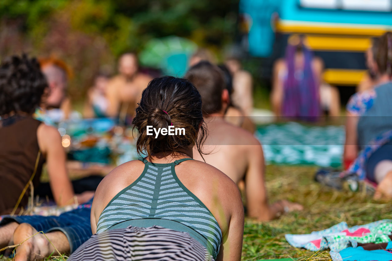 REAR VIEW OF PEOPLE RELAXING IN SWIMMING POOL