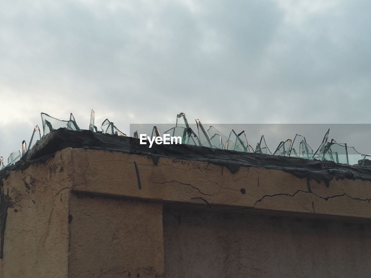 LOW ANGLE VIEW OF HOUSE AGAINST CLOUDY SKY