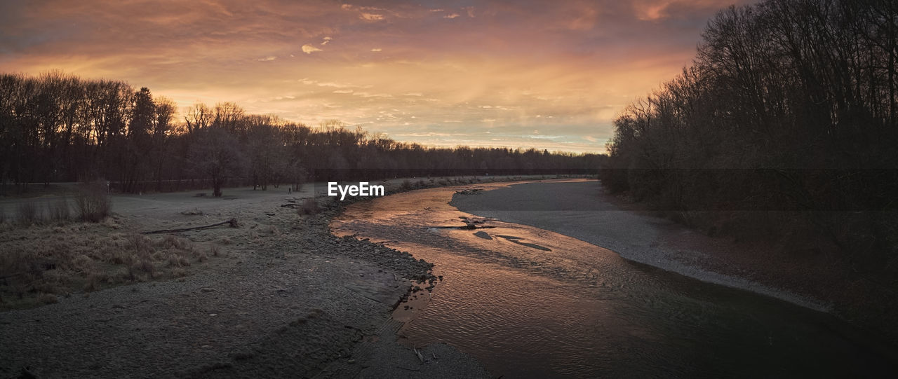 Scenic view of snow covered river valley against sky during sunrise