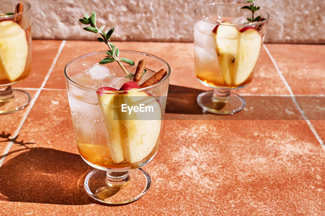 Fresh and healthy cocktail or mocktail with apple, ice, cinnamon and herbs. refreshing summer drink.