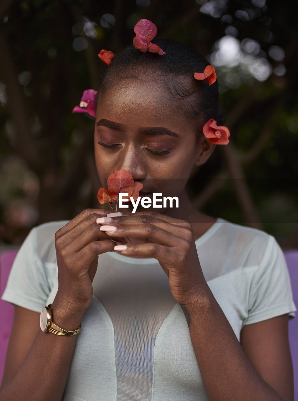 Portrait of young woman smelling a flower