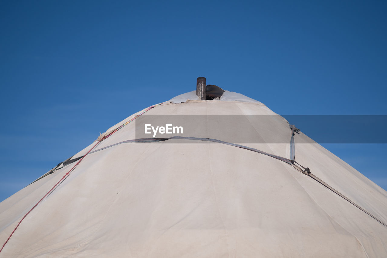 High section of tent against blue sky