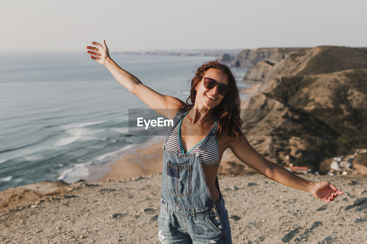 Woman wearing sunglasses while standing at beach