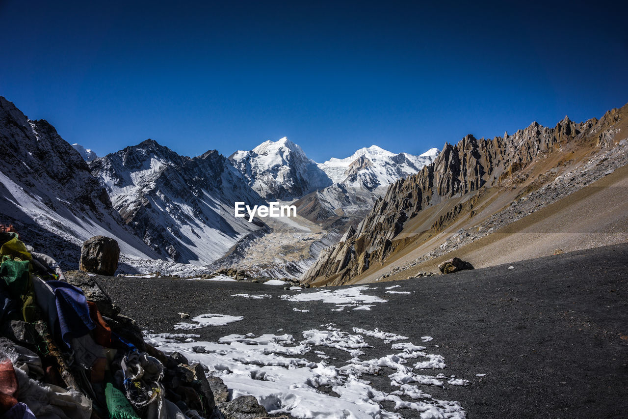 Scenic view of snowcapped mountains against clear blue sky