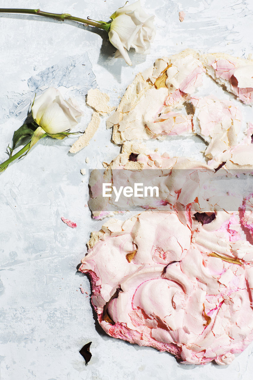 High angle view of roses and sweet food on table