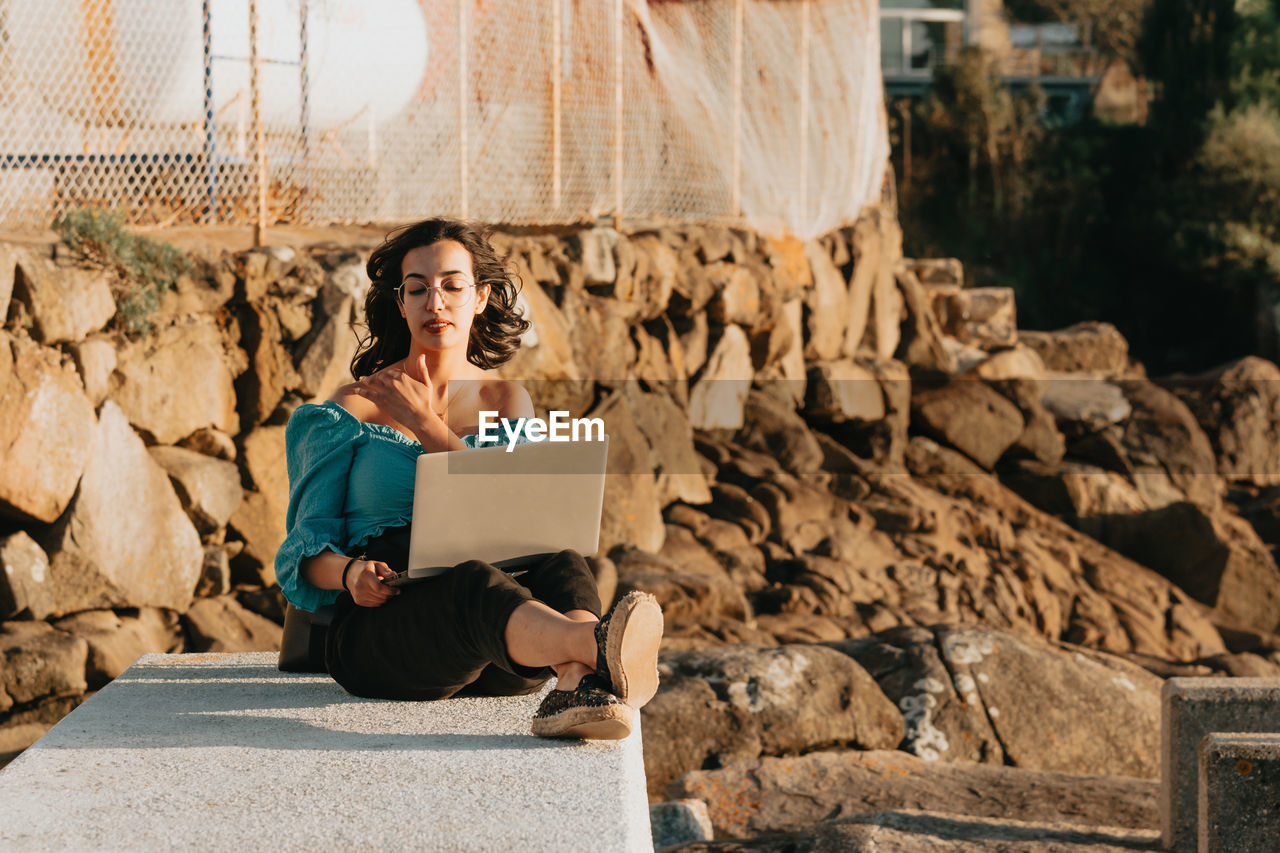 Portrait of woman sitting on rock