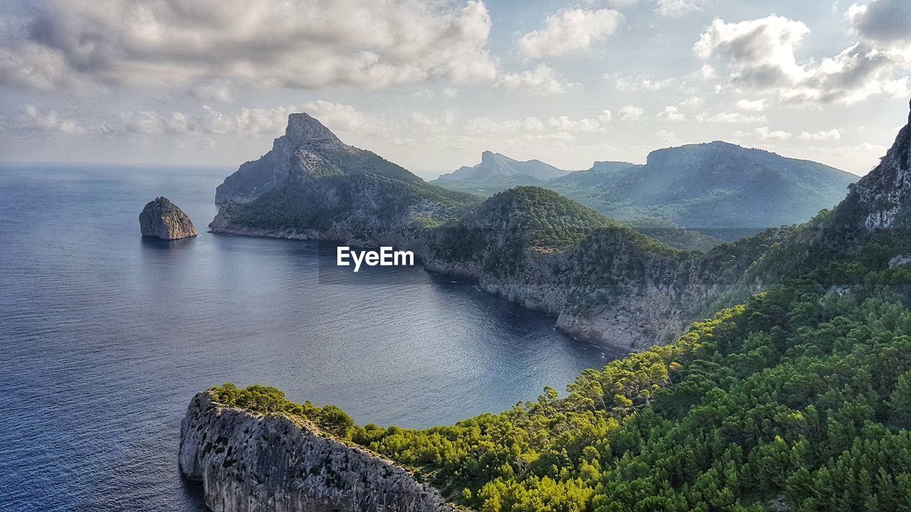 Scenic view of sea and mountains against sky