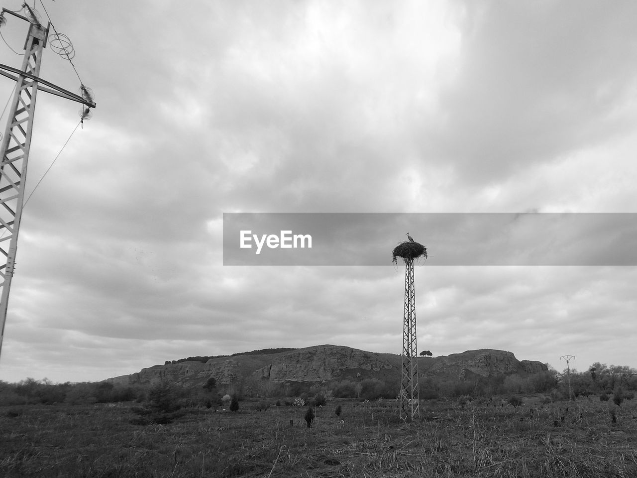 sky, cloud, tower, black and white, nature, wind, environment, monochrome photography, technology, monochrome, landscape, architecture, no people, windmill, land, built structure, day, outdoors, mountain, overhead power line, communication, scenics - nature, power generation, low angle view, non-urban scene, communications tower, broadcasting, electricity, wind turbine, beauty in nature, tree, wind power