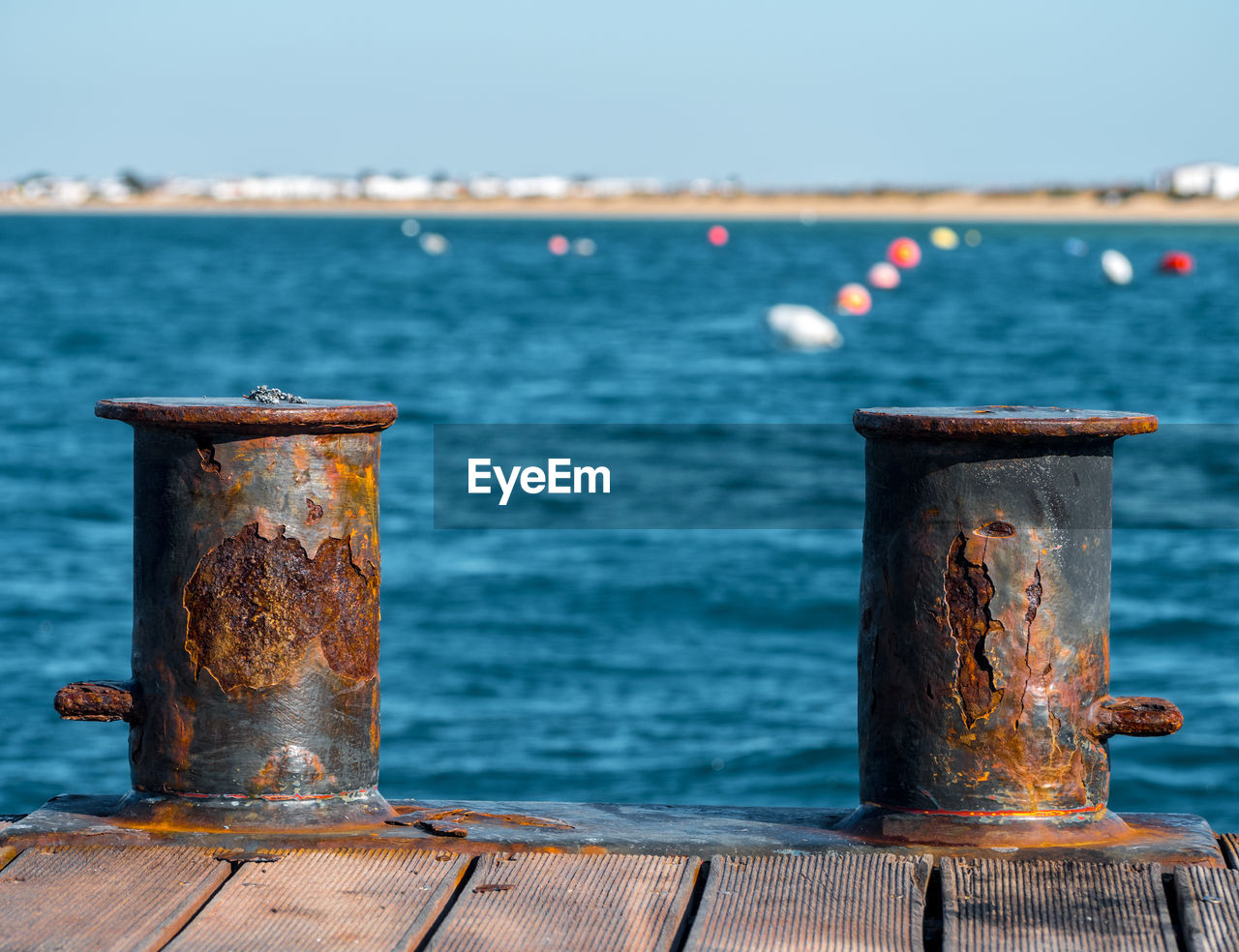 CLOSE-UP OF RUSTY RAILING AGAINST PIER