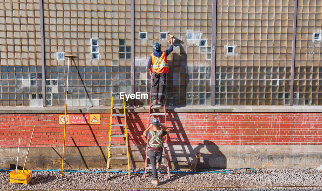 Rear view of men working on wall