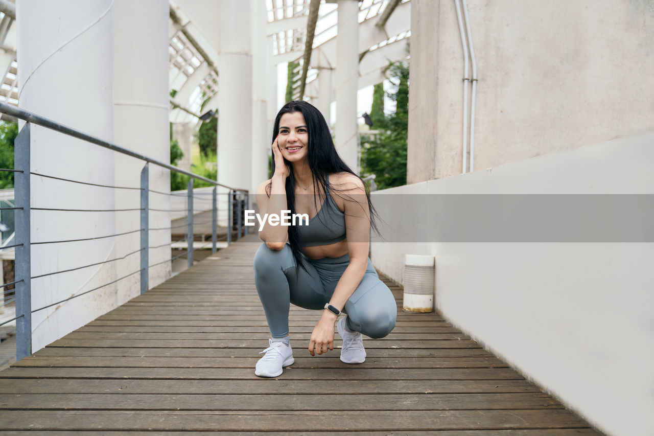 PORTRAIT OF WOMAN SITTING ON STEPS