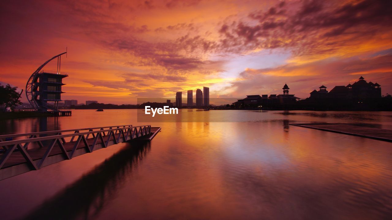 View of city at waterfront during sunset