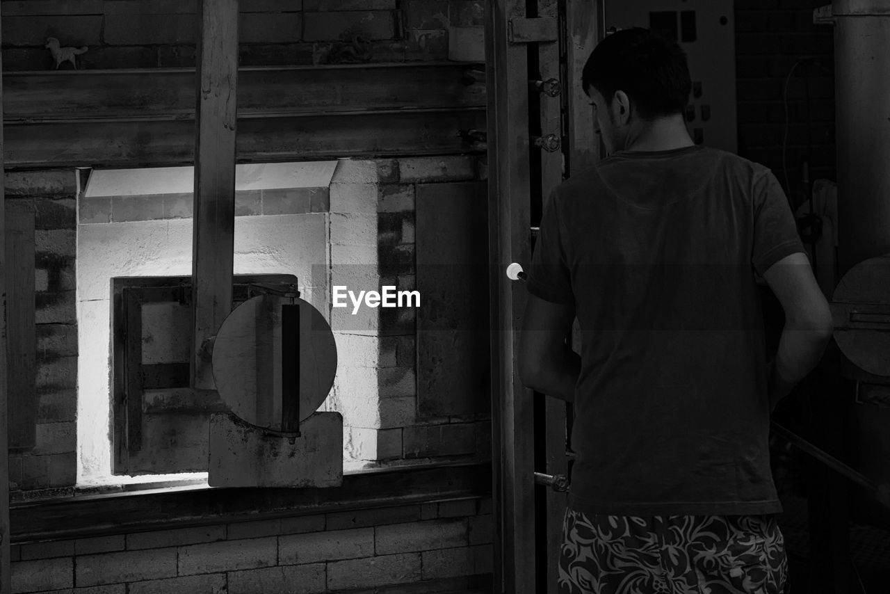 Rear view of man standing by wall