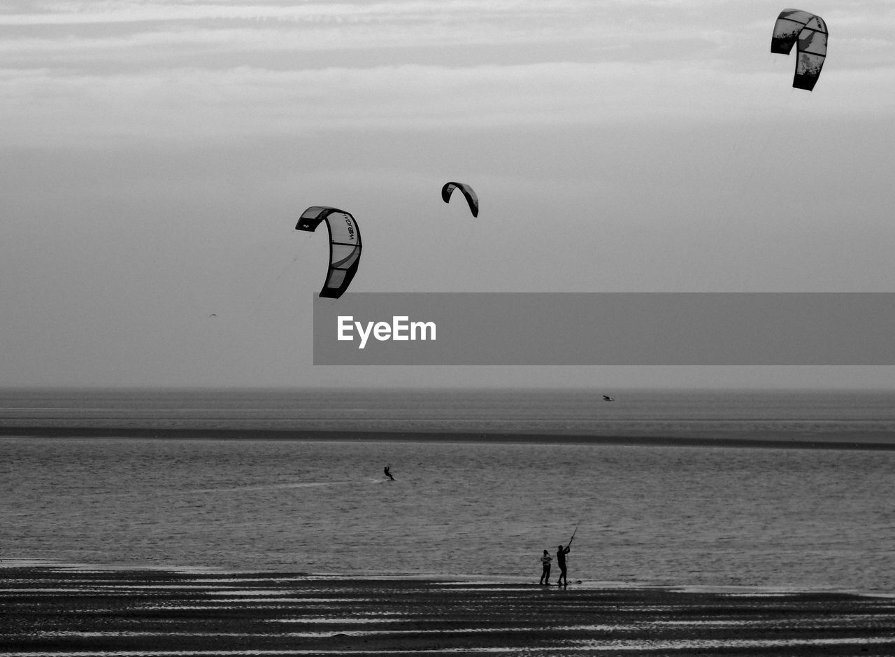 PERSON PARAGLIDING AGAINST SEA