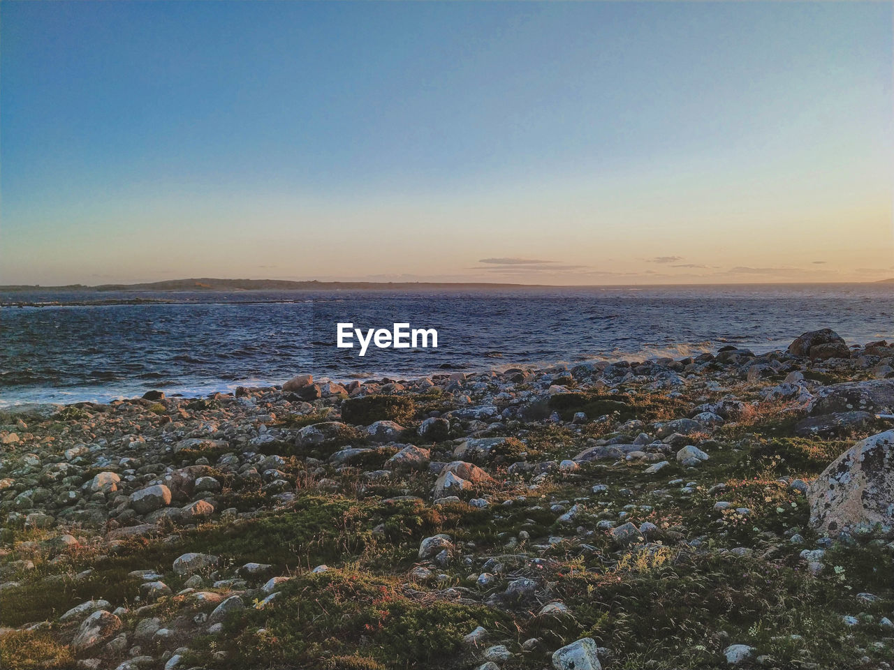 Scenic view of sea against clear sky during sunset