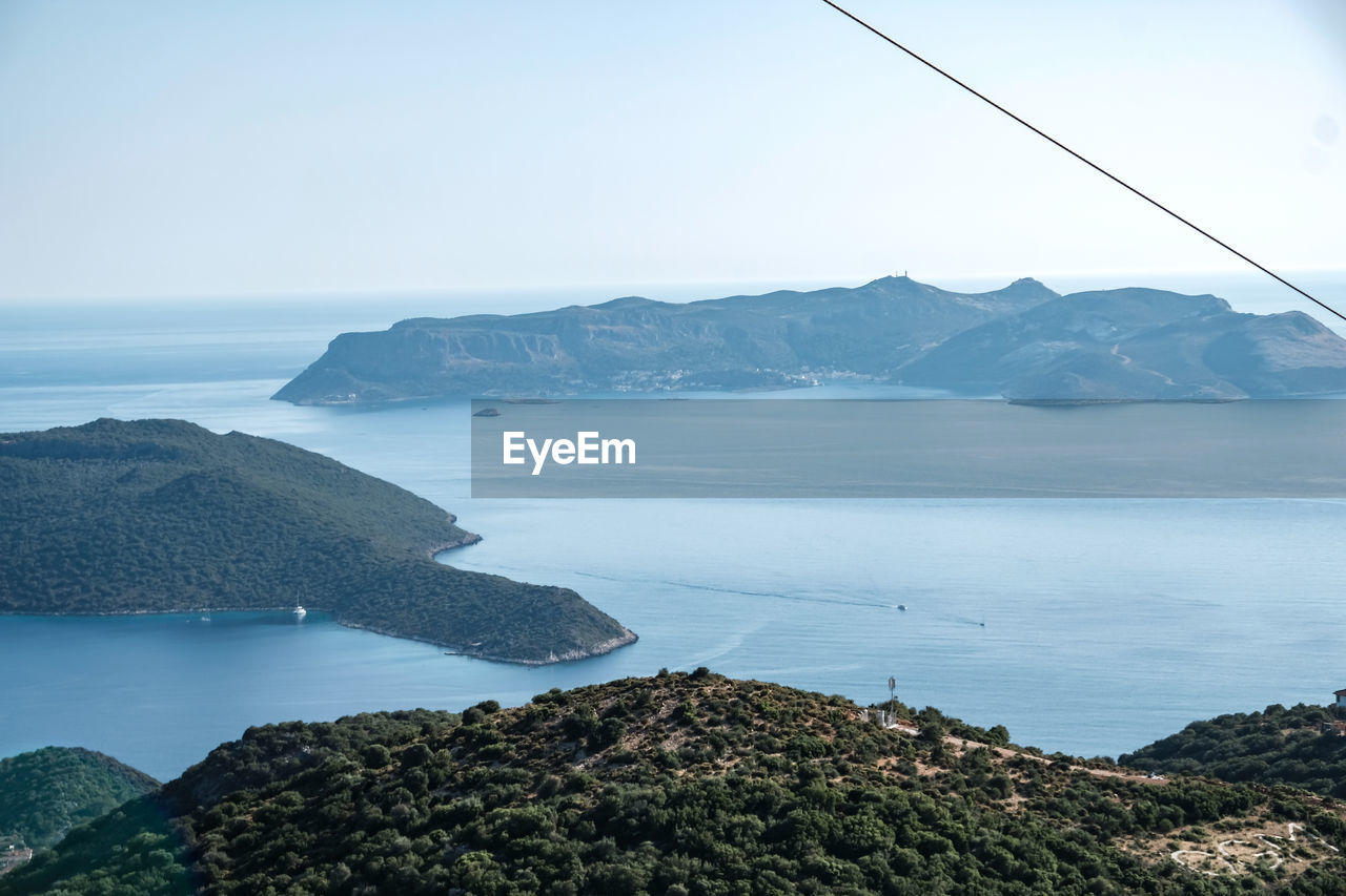 Scenic view of sea and mountains against clear sky