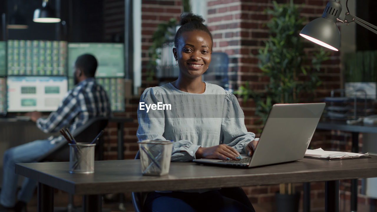 Portrait of young businesswoman using laptop at office