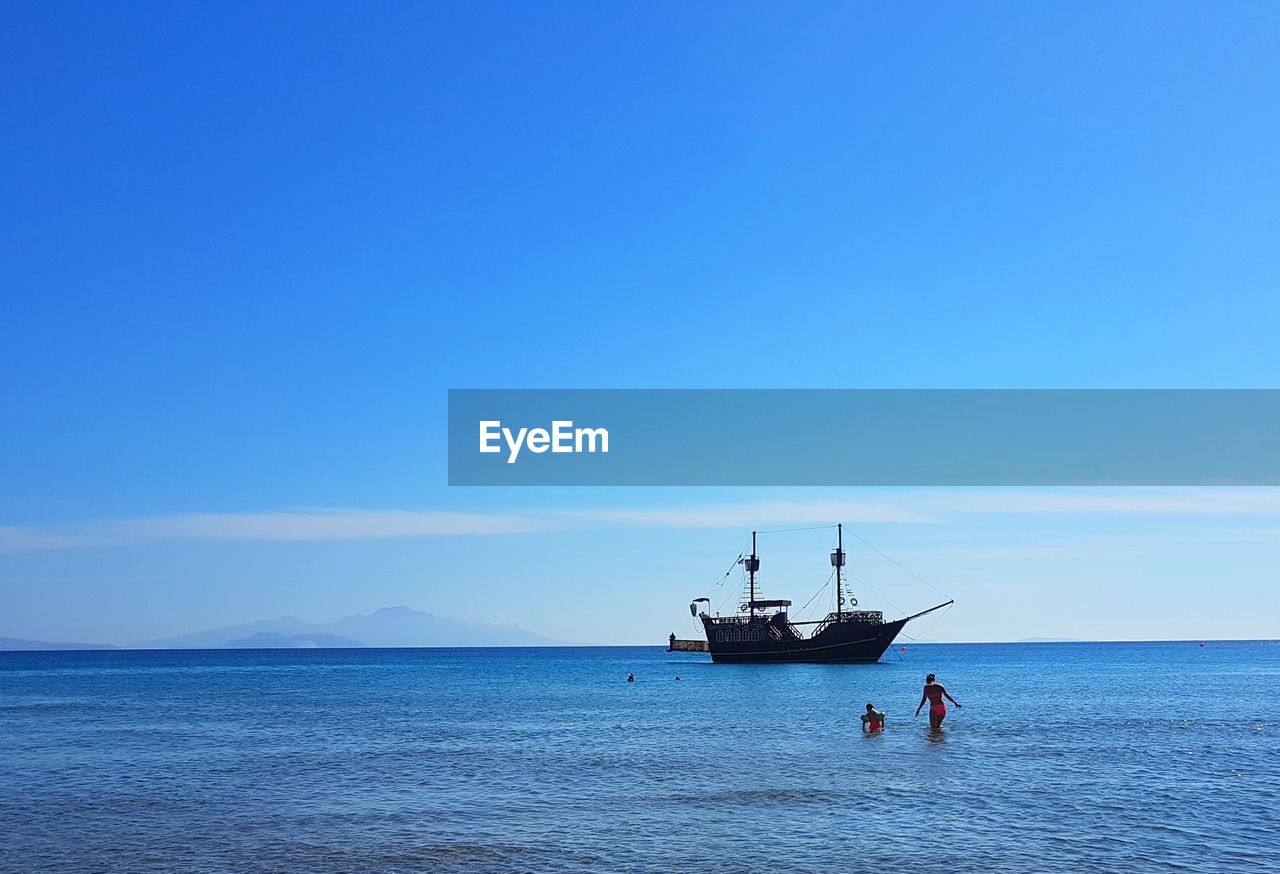 BOAT SAILING IN SEA AGAINST CLEAR SKY